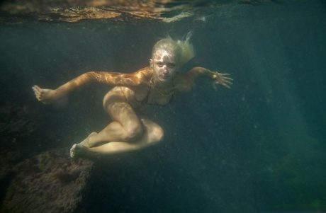 Ukrainian beauty Nika N swims underwater for nude posing inside a cave