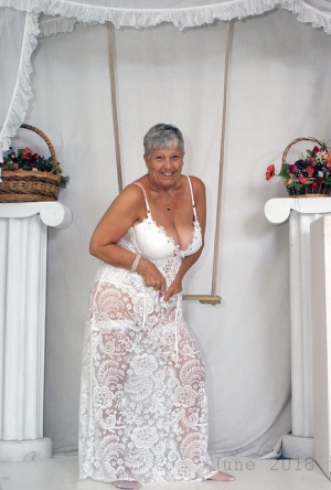 Short haired oma Savana models all white lingerie and hosiery on a swing