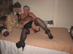 Silver haired granny Girdle Goddess masturbates on her bed in stockings