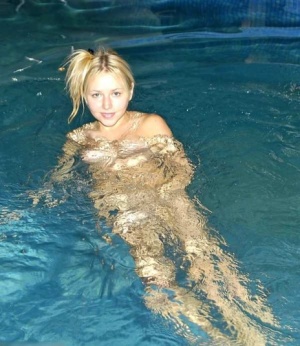 Young looking blonde removes a pink swimsuit to go skinny-dipping