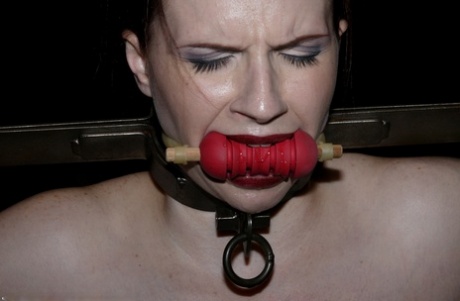 Claire Adams sports red lips during the course of a hardcore bondage scene