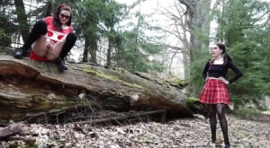 Sexy brunette takes a piss on a fallen tree while her girlfriend watches