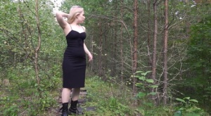 Blonde girl hikes up a black dress to piss in the woods while wearing Docs