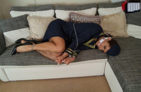 Hot stewardess is left in her uniform on a sofa while restrained and gagged 54089492