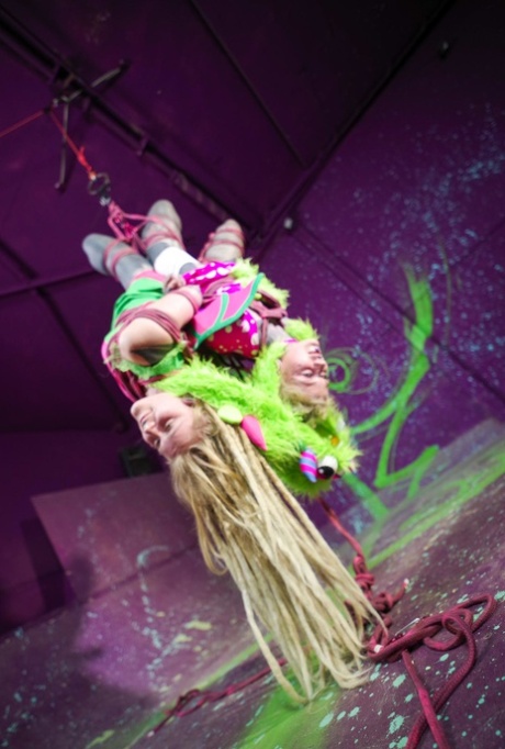 Heavily tattooed girls are suspended from a ceiling in strange outfits 51729842
