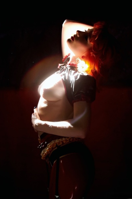 Natural redhead Ulorin Vex removes latex clothing in a garter belt and boots 36289825