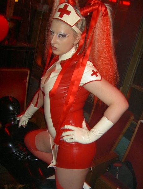 Latex attired nurse Joanne Lafontaine uses Darkwing Zero as her slave 94331410
