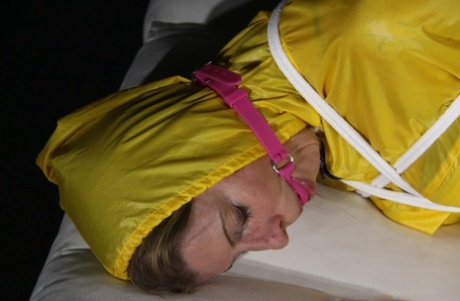 Caucasian chick Pia is ball gagged and hogtied in a yellow rain suit 76695915